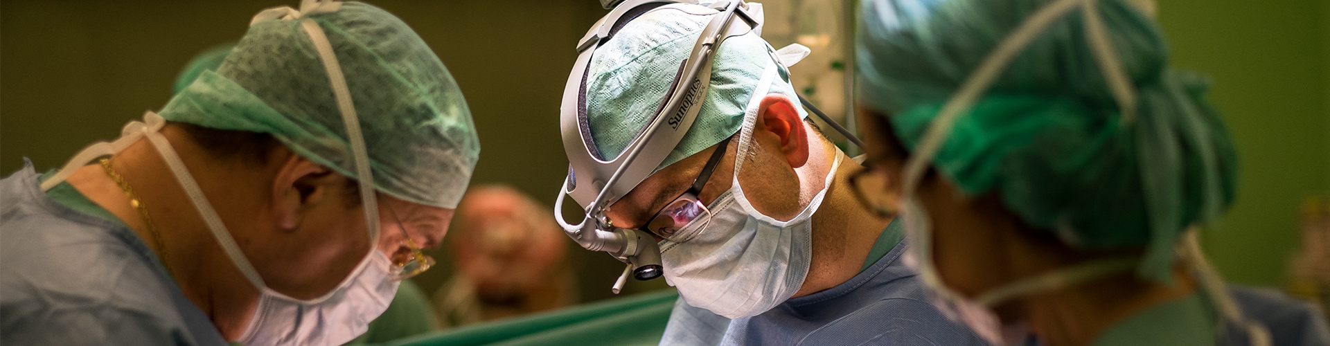 Dieses Bild zeigt Dr. med. Jon Jones und zwei weitere Fachkräfte während einer Operation.